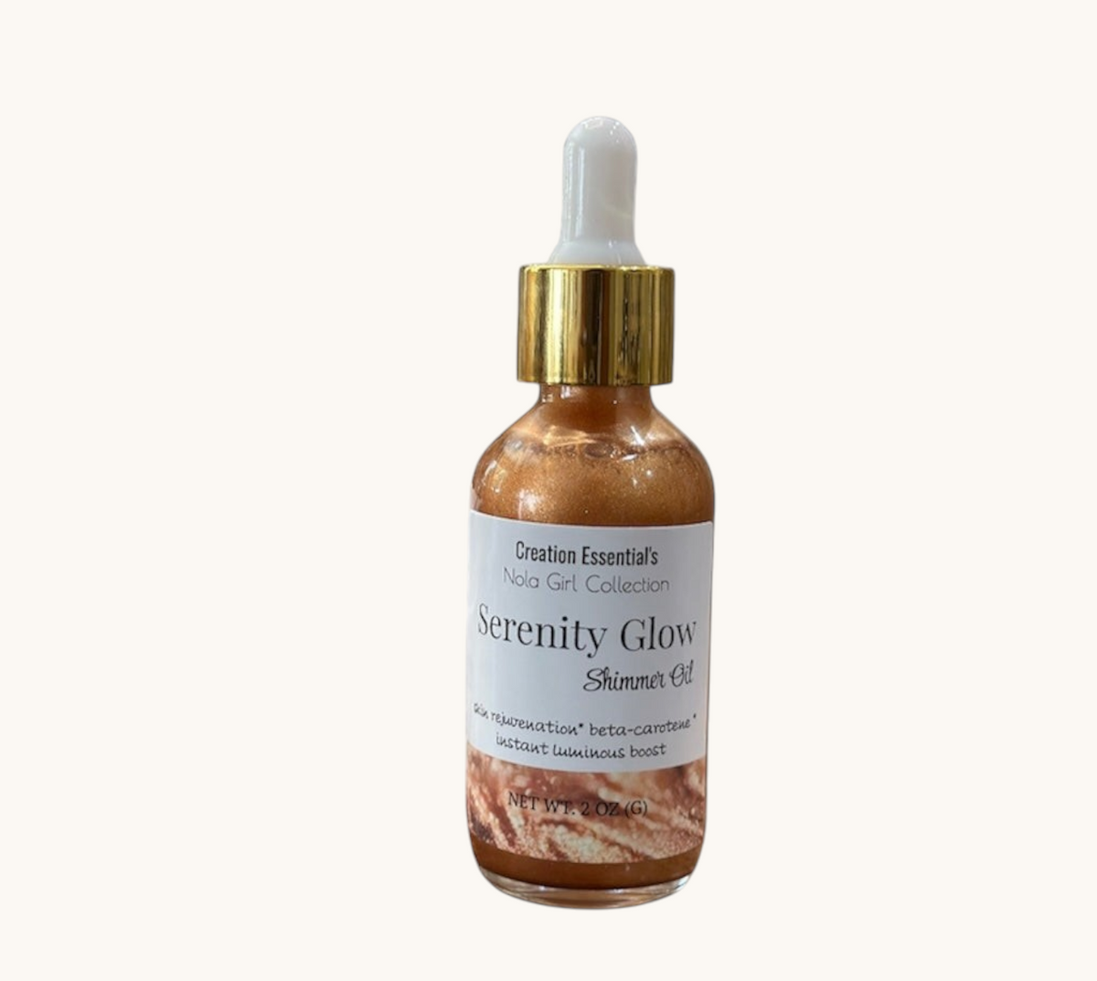 Creation Essential's Natural Body Serenity Glow Shimmer Oil in a glass dropper bottle on a marble pedestal.