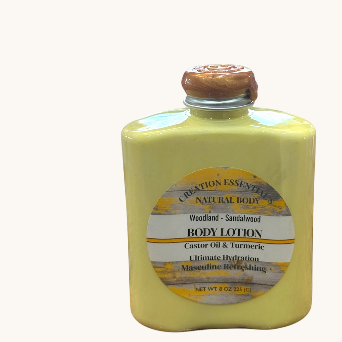 Creation Essential's Natural Body Woodland Sandalwood body lotion in a yellow bottle with turmeric and aloe vera
