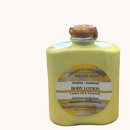 Creation Essential's Natural Body Woodland Sandalwood body lotion in a yellow bottle with turmeric and aloe vera