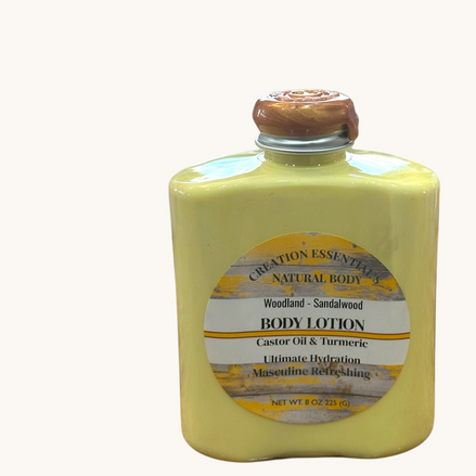 Creation Essential's Natural Body Woodland Sandalwood body lotion in a yellow bottle with turmeric and aloe vera