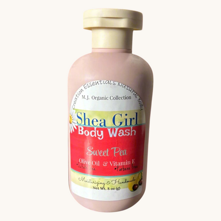 Creation Essential's Natural Body Shea Girl Sweet Pea body wash in a pink bottle on a bathroom vanity.