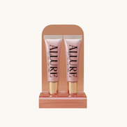 Two Allure lip gloss tubes on a marble surface