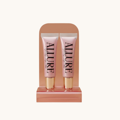 Two Allure lip gloss tubes on a marble surface