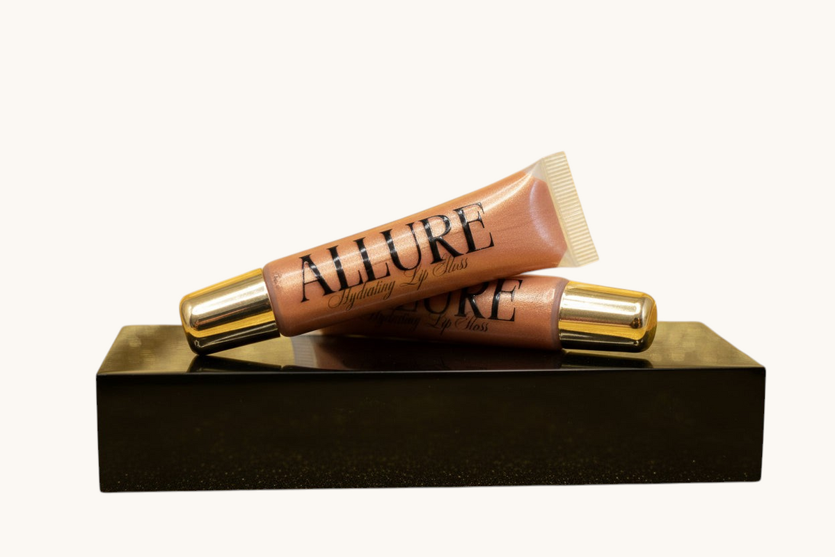 Two Allure lip gloss tubes on a marble surface