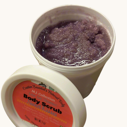 Two containers of body scrub with a purple scrub and visible label on a gray surface with green leaves.