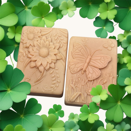 Creation Essential's Natural Body Tropical Fusion soap bars with floral and butterfly embossed designs on clover leaves