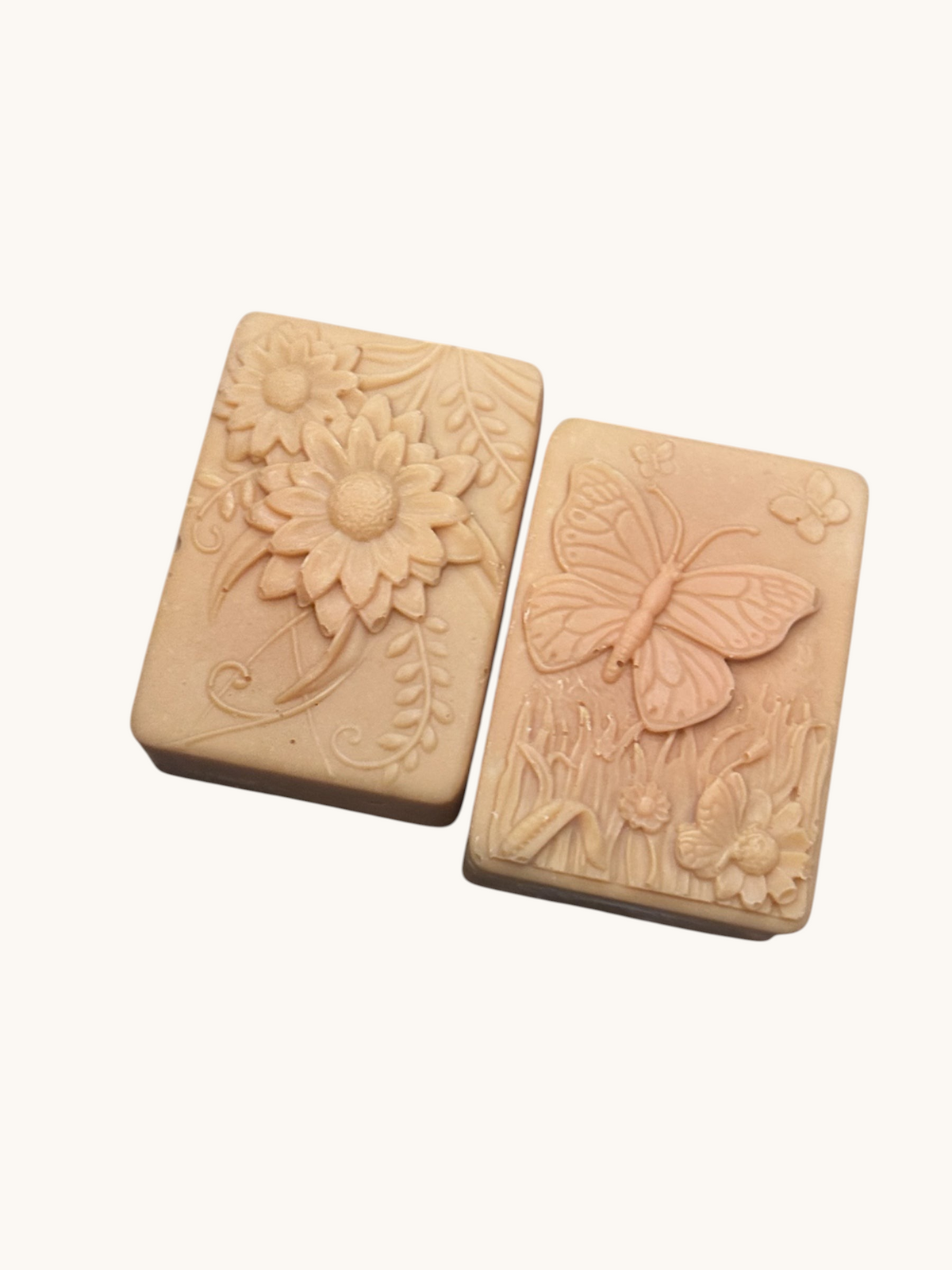 Creation Essential's Natural Body Tropical Fusion soap bars with embossed floral and butterfly designs on marble