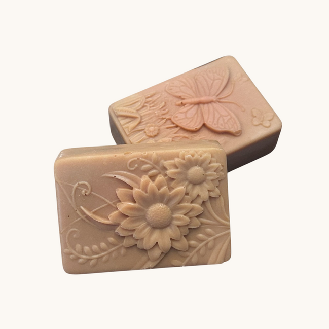 Creation Essential's Natural Body Tropical Fusion soap bars with embossed floral and butterfly designs in beige